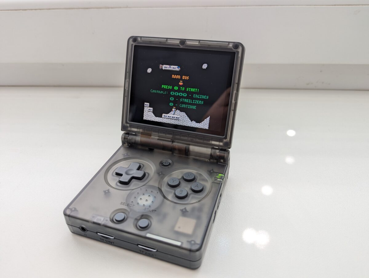 Handheld console showing Moon Bus game running.